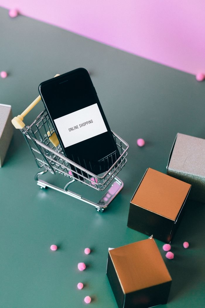 Crafting Captivating Headlines: Your awesome post title goes here Conceptual image of online shopping with a smartphone in a miniature cart.